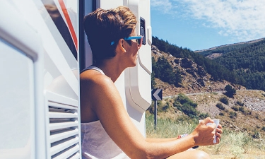 young woman enjoying the view from her rv